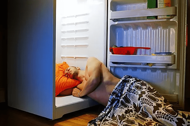 Person laying with their head in a fridge