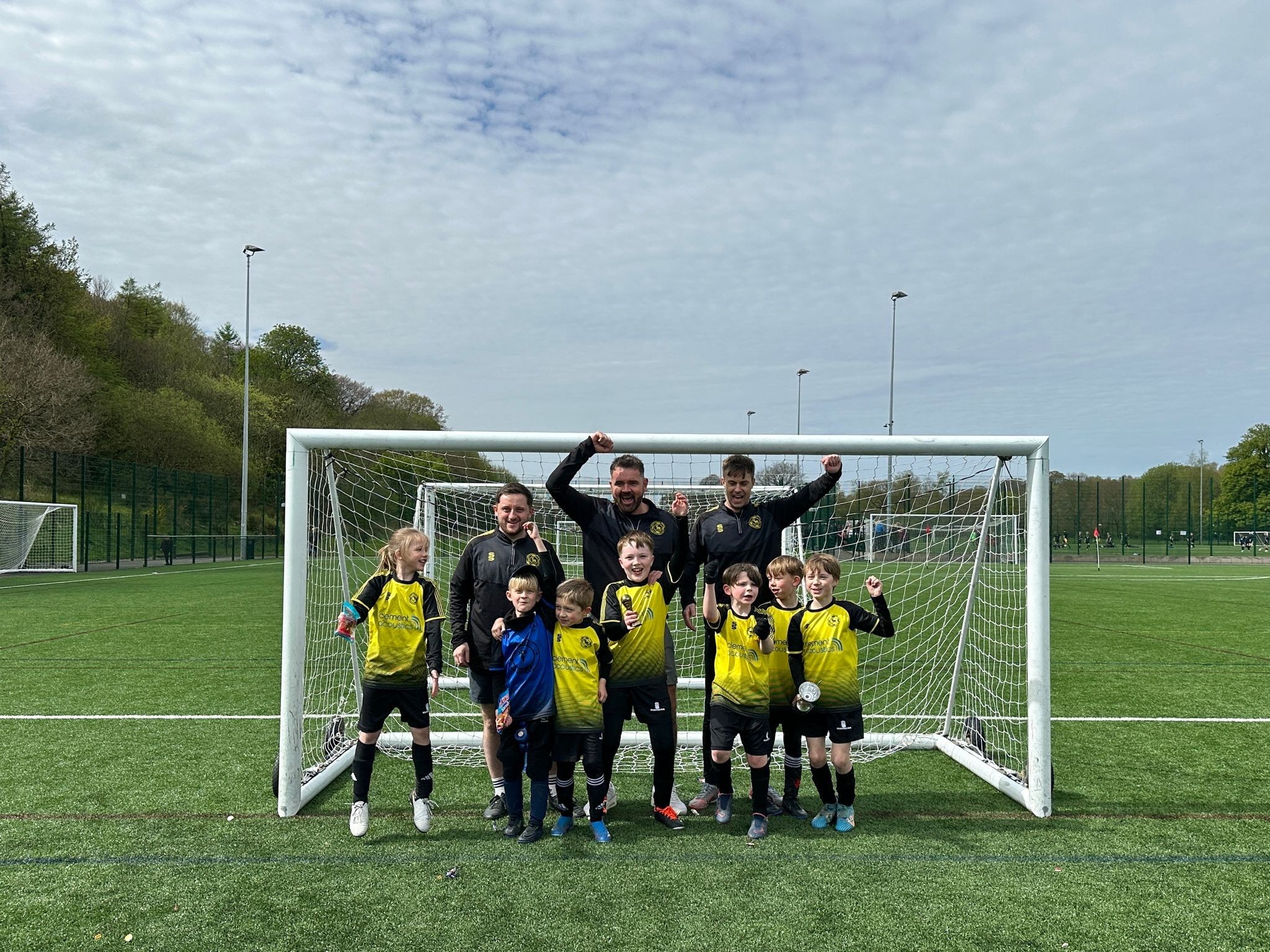 Football team poses in front of goal.